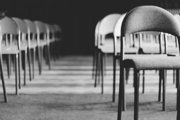 grayscale photo of empty folding chairs